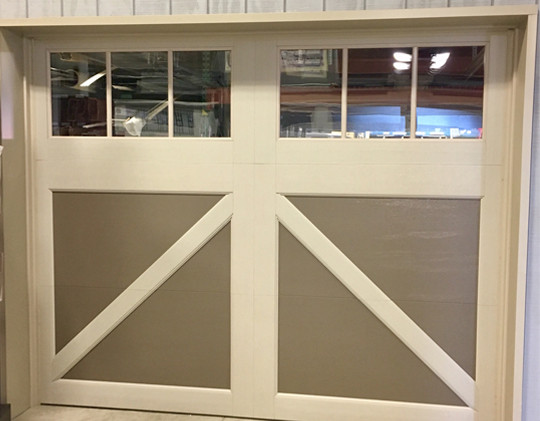 A closed two-paneled garage door with beige panels, white trim, and top windows divided into six small squares each. The design features diagonal and horizontal cross beams—perfect for those seeking cheap garage doors.